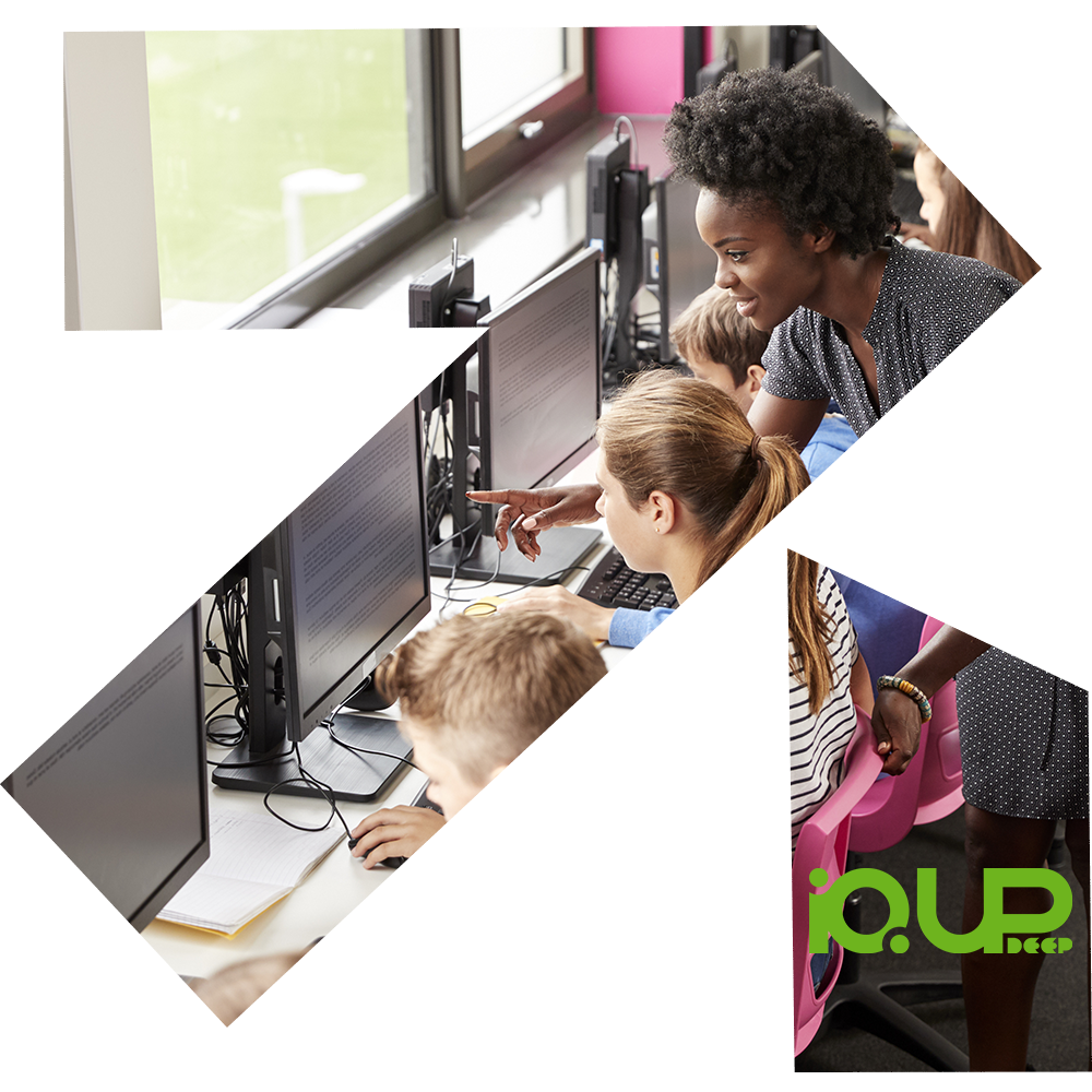 Children learning on computers in a classroom with a teacher