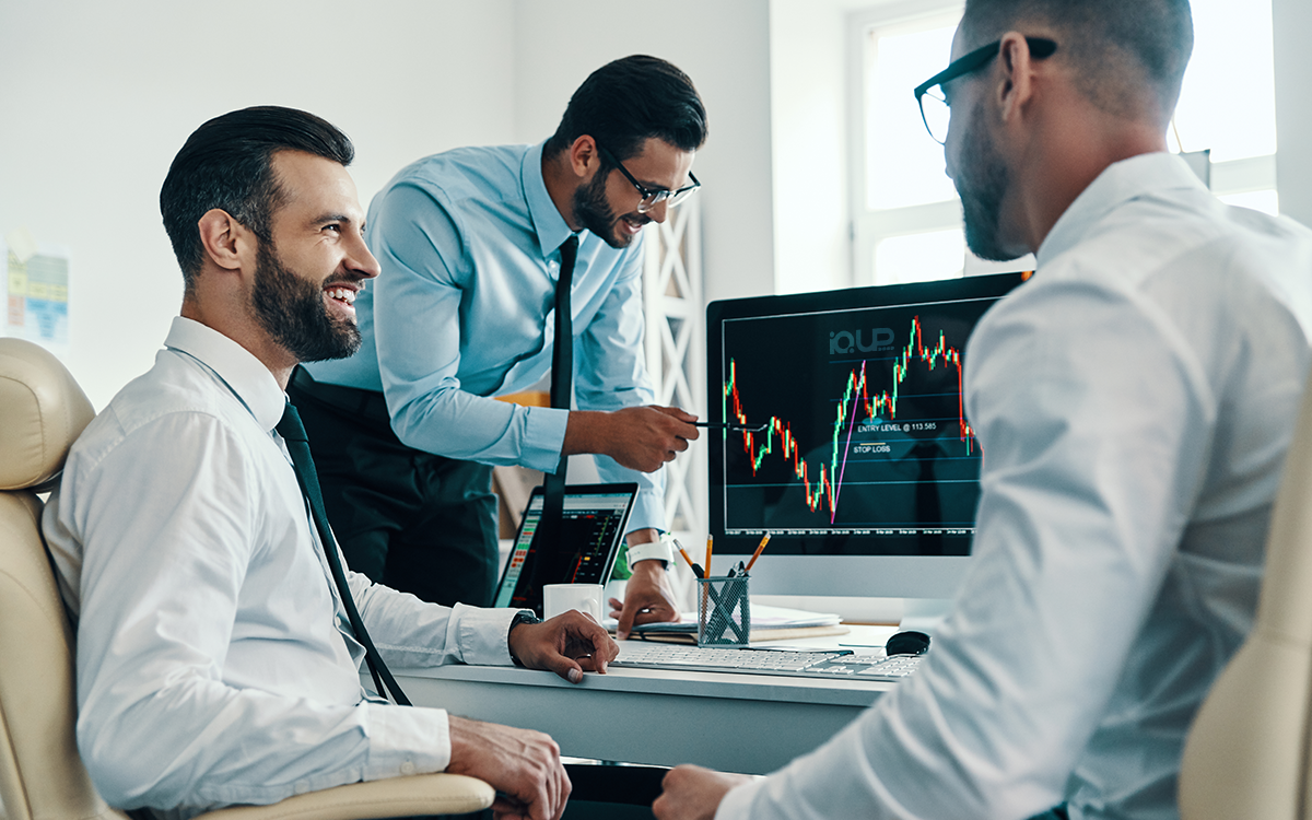 Three colleagues reviewing growth charts together at a desk
